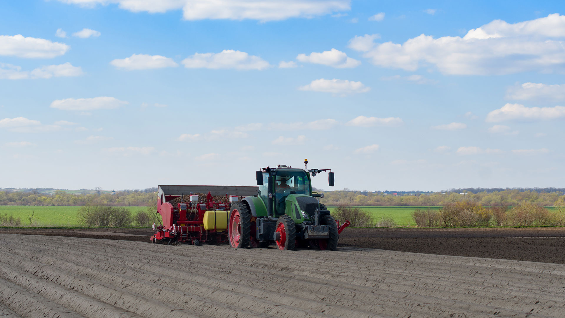 tractor planting potatoes in field